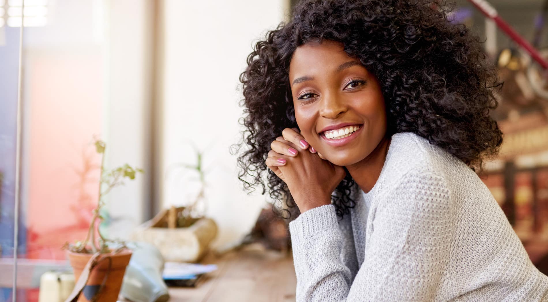 Young African American woman smiling while sitting in a cafe Woman happy with his cosmetic dental treatment in Salt Lake City UT