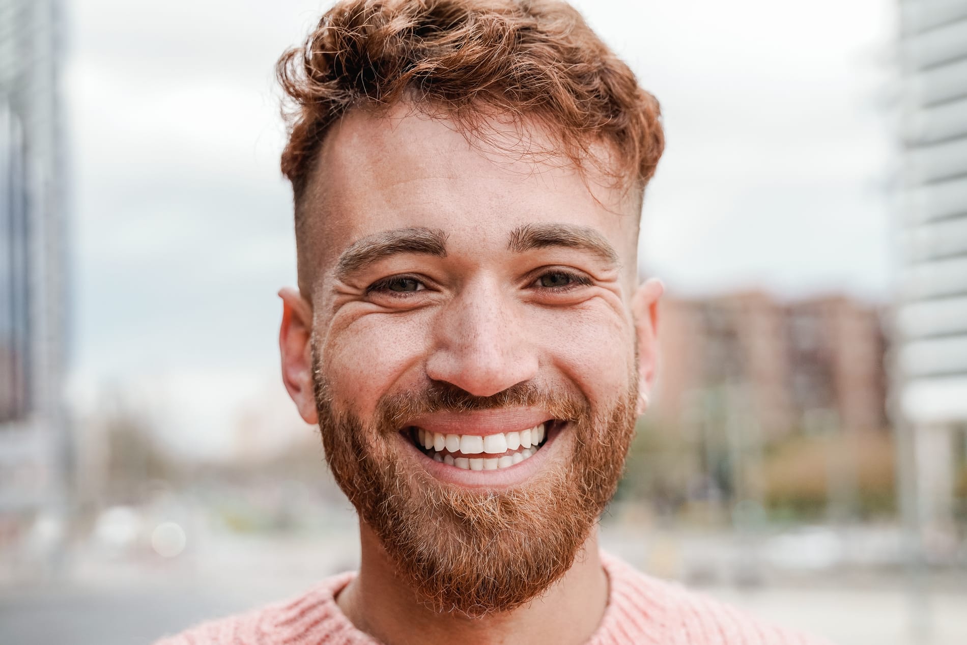 Happy ginger hair man smiling on camera outdoor - Redhead authentic people concept Man on his way to a general dental appointment in SLC UT
